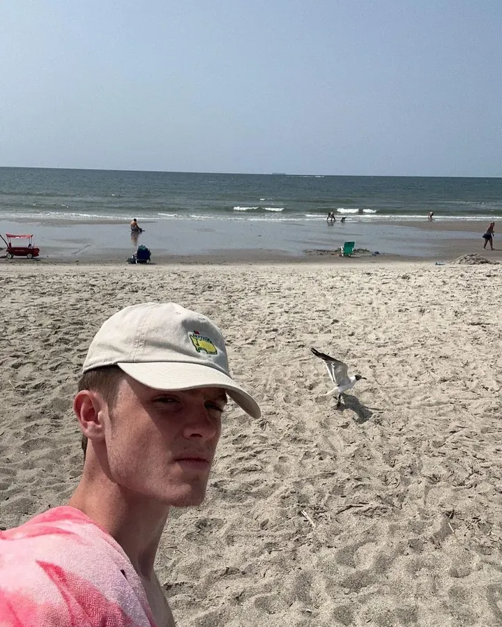 Benjamin Sachwitz on a beach, taking a selfie